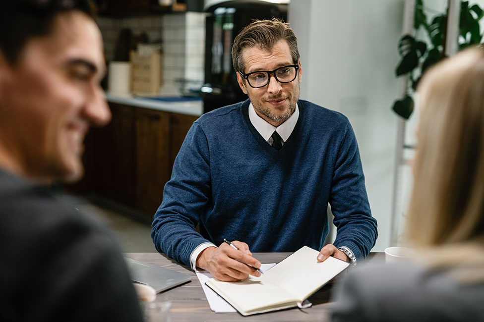 male advisor sitting down with a husband and wife couple